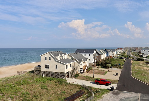 A wide aerial view of homes that stand along the Atlantic Ocean sand dunes and Highway 12 in Kitty Hawk, North Carolina—a popular Outer Banks destination.