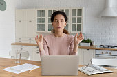 Woman sit near laptop makes calming exercises to reduce stress