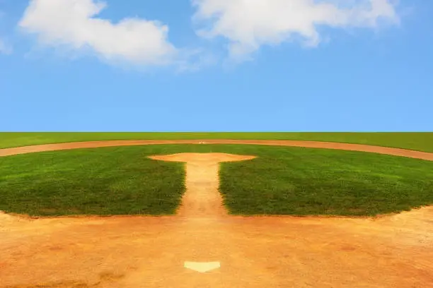 A Baseball field looking out to an endless horizon with a bright blue sky with fluffy white clouds