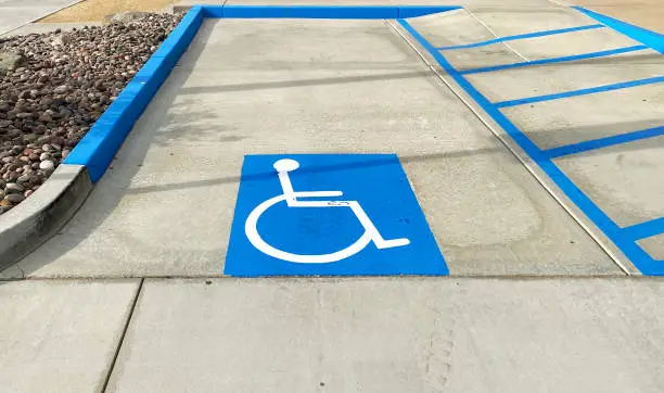 Photo of designated sign posted disable space parking lot commercial disabled building entrance handicap car park