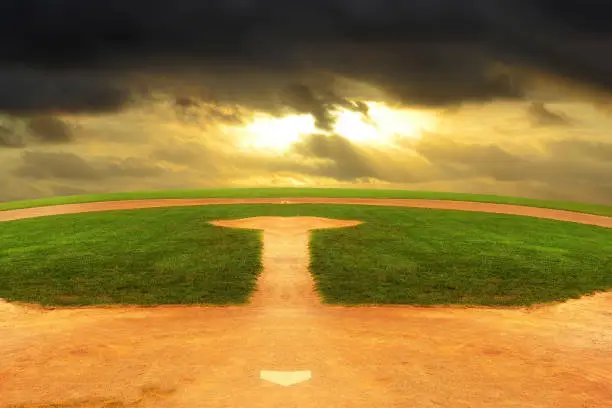 A Baseball field looking out to an endless curved horizon and a dark stormy sky.