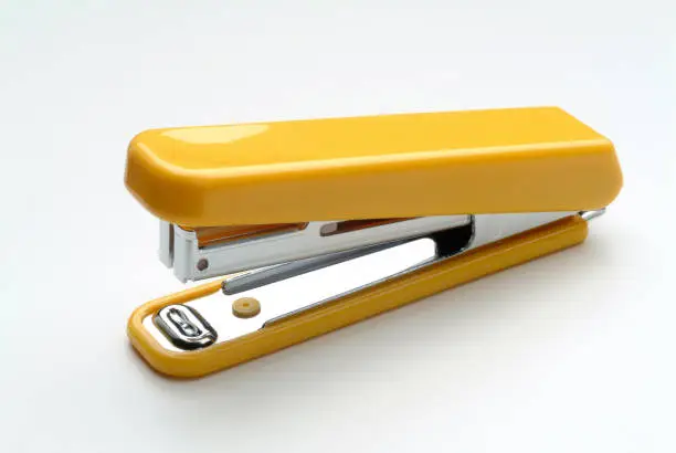 Yellow stapler on white background.