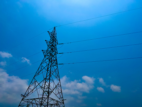 Electricity transmission pylon against blue sky at dusk. Electricity Power Grid High Voltage