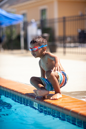 Multi race Boy learning to swim. 
Supervised by Mom. 

Shallow DOF