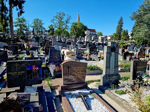 The cemetery (Cimetière des Chaprais) is the largest cemetery of Besancon. Founded in 1824 it houses also a small church named L'église Saint-Martin. The image shows several graves, captured during summer season.