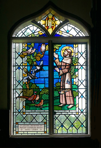 Roxton, Bedfordshire, England -  July 23, 2021: Stained glass window depicting St Frances with birds.