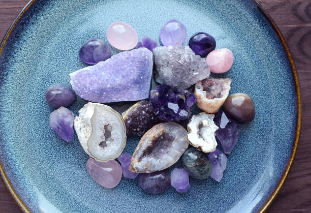 Beautiful semi-precious stones of different colors on a ceramic blue plate. Druses, crystals and geodes of amethyst, round stones of amethyst and rose quartz and agate. Beautiful semi-precious stones of different colors on a ceramic blue plate. Druses, crystals and geodes of amethyst, round stones of amethyst and rose quartz and agate. agate stock pictures, royalty-free photos & images