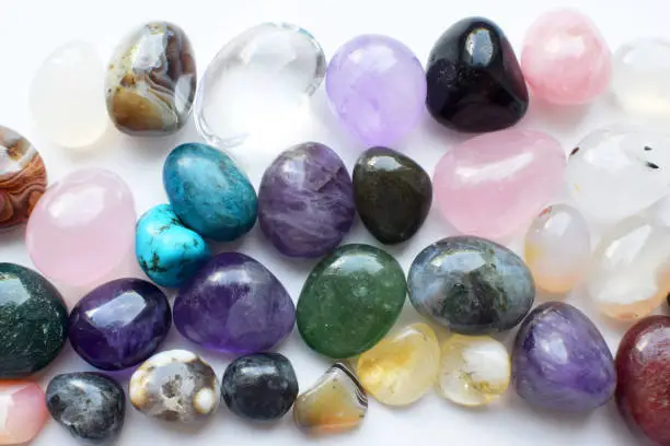 Gemstones of different colors. Amethyst, rose quartz, agate, apatite, aventurine, olivine, turquoise, aquamarine, rock crystal on a white background..