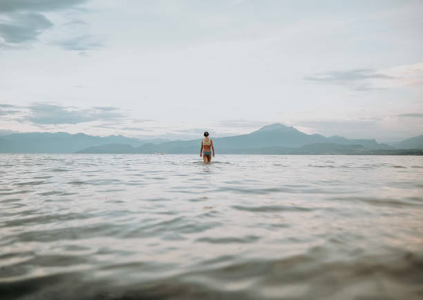 istock A girl walking into the water 1415860303