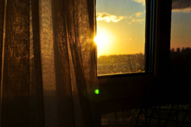 istock The golden sunset sun shines through the curtain 1415860314