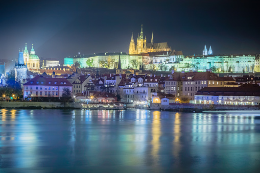Hradcany quarter and Vltava river at night with blurred boat movement, Prague, Czech Republic