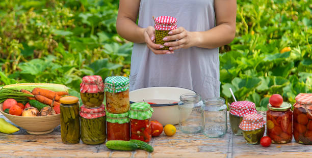 istock A woman preserves vegetables in jars. Selective focus. 1415862390