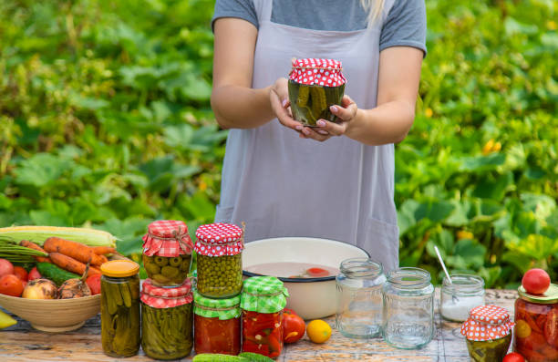 istock A woman preserves vegetables in jars. Selective focus. 1415862406