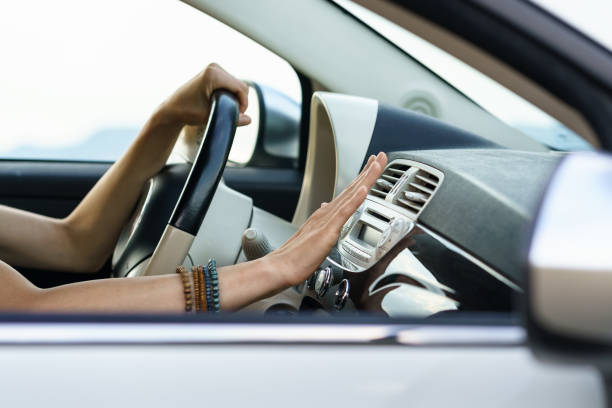 istock Man hand check air conditioning panel in car. Male driver holding hand at conditioning system 1415862494