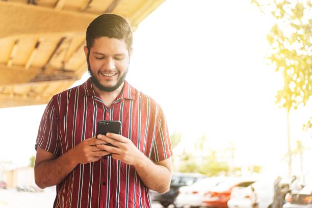 istock Young latin american man using a mobile phone. 1415862566