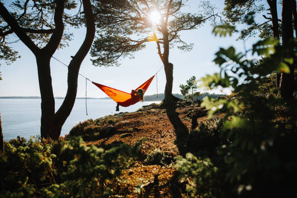 ノルウェーのアウトドアアドベンチャー:ハンモックは自��然の中でリラックス - summer women hammock nature ストックフォトと画像