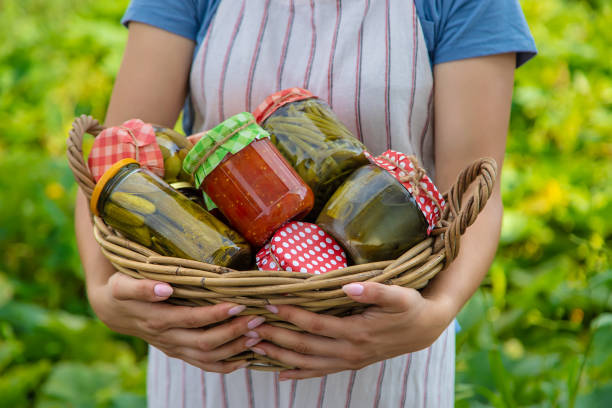 A woman preserves vegetables in jars. Selective focus. Food.