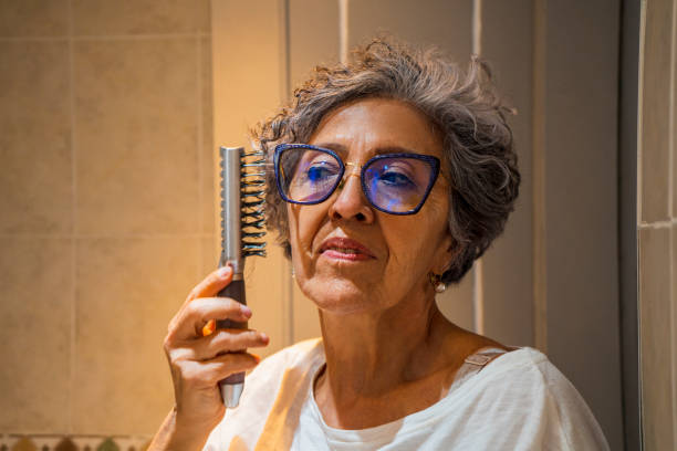 istock Old woman combing her hair 1415864446