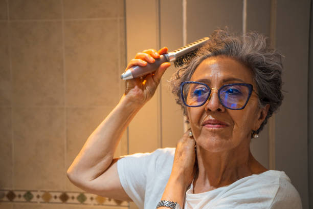 istock Old woman combing her hair 1415864679