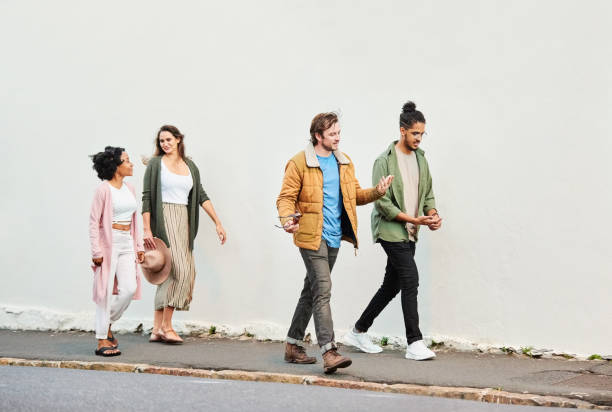 Group of friends walking against a white wall outside