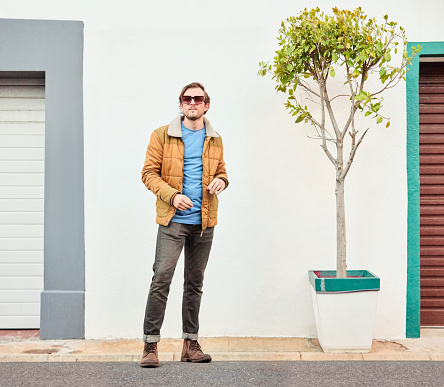 Portrait of a handsome young man in stylish outfit standing outdoors