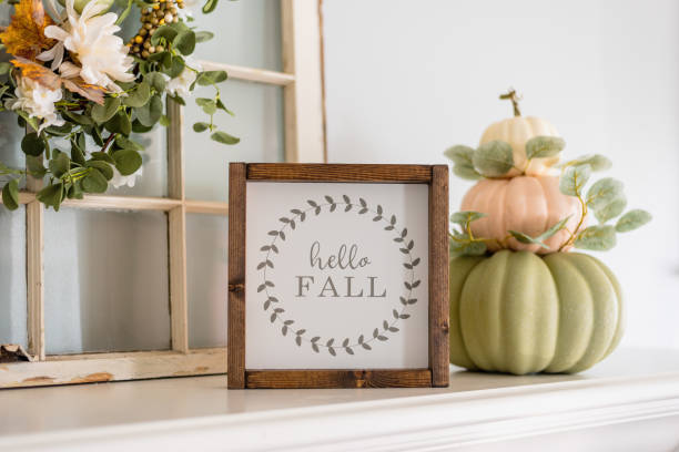 Contemporary stacked pumpkins on the mantel with a sign that say stock photo