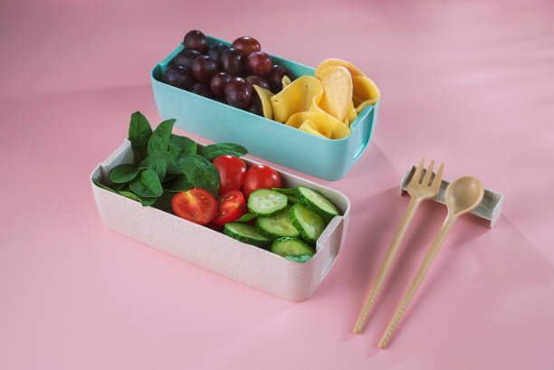 istock Office or school vegetarian lunch box. Cucumber, tomato, spinach, cookie, cheese lunch box on light background high angle view 1415865368