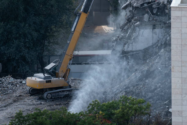 les travaux de démolition sont effectués avec la machine de démolition du bâtiment. - water cannon photos et images de collection