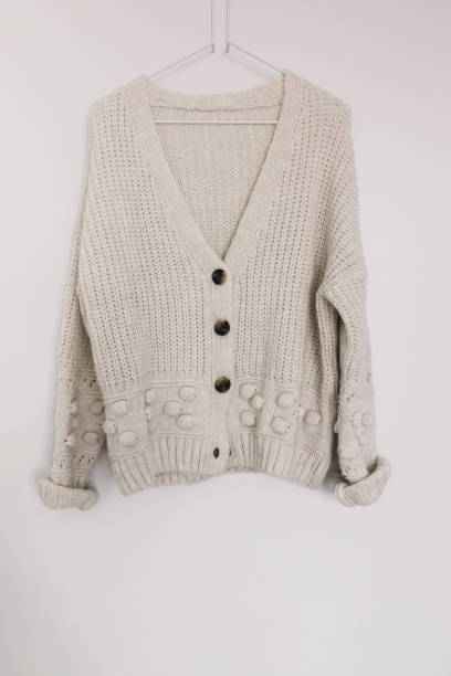 istock White woolen knitted sweater on the hanger over the white wall 1415866915