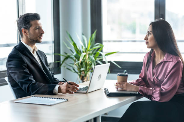 personas de negocios inteligentes que trabajan juntas con computadoras portátiles mientras hablan en una startup moderna. - back office fotografías e imágenes de stock