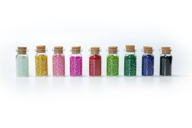 istock small transparent bottles with colorful beads on a white background 1415874647