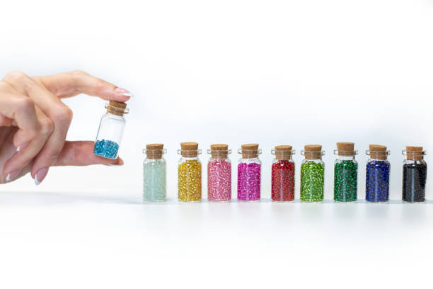 istock small transparent bottles with colorful beads on a white background 1415874734