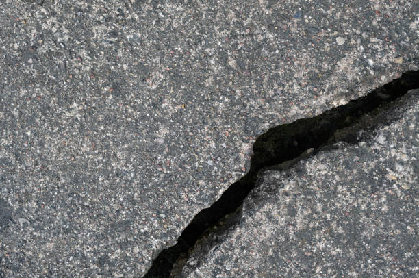 istock Old aged weathered cracked grey black tarmac texture pattern, large detailed damaged textured asphalt grungy background flat lay, horizontal rough grained broken pattern macro closeup grunge copy space 1415877044