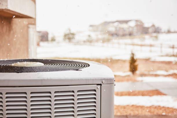 istock Residential air conditioning unit with snow in winter. Space for text 1415880254