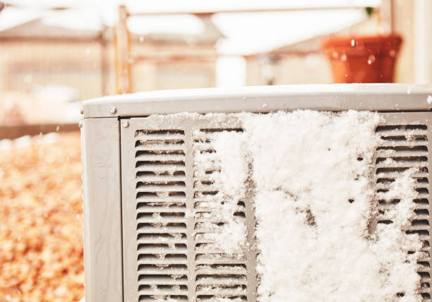 istock Residential air conditioning unit with snow in winter. Space for text 1415880271