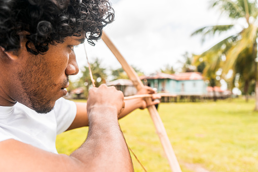 Afro-descendant latin teenager on the caribbean coast of nicaragua taking aim with a bow and arrow