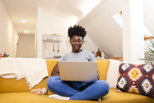 istock Afro woman enjoying coffee while working online on the sofa 1415887660