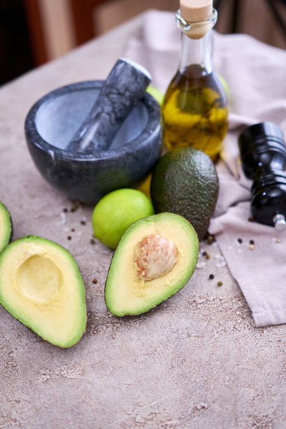 istock fresh avocado cut in half and marble mortar on grey concrete table 1415888240