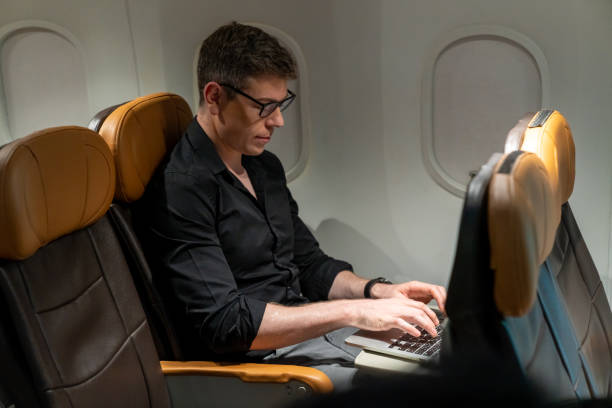 istock Caucasian businessman working on laptop computer while travel on airplane. 1415891526