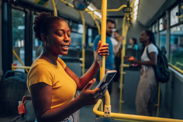 istock African american woman using smartphone while riding a bus in the night 1415892094