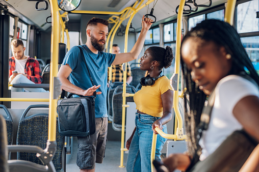 Amigos multirraciales hablando mientras viajan en autobús por la ciudad photo
