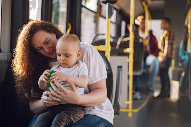 Mother and her child riding in a bus during a day. stock photo