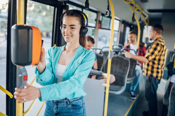 istock Woman paying a bus ticket via smartphone during a ride 1415892118