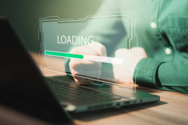 istock Man using laptop for download and waiting to loading digital business data form website, concept of waiting for load of loading bar. 1415896336