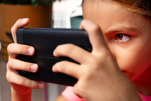 istock Girl looking at phone screen in close-up 1415906768