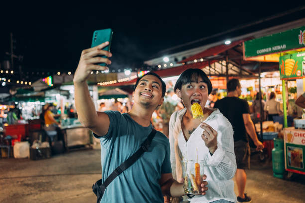istock Friends taking selfies on night market 1415914970