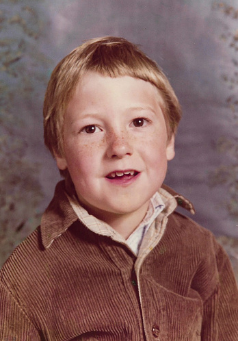 Stock photo showing close-up, 1970s formal portrait of young boy with freckles.