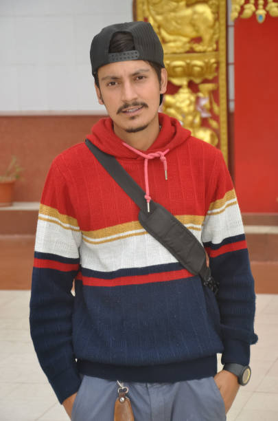 istock Front view of a good looking Indian young guy wearing cap backwards with looking at camera while posing with hands on pocket 1415920825