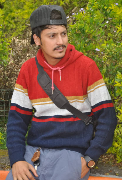istock A handsome Indian young guy wearing cap backwards with looking sideways while sitting outdoors 1415921153