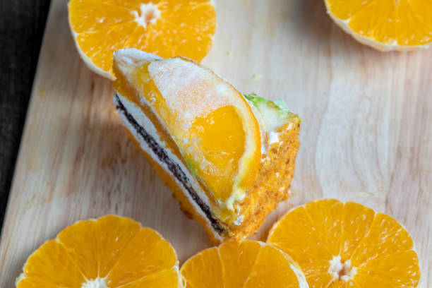 sliced fresh oranges and a piece of orange dessert, orange cake with juicy oranges on the table